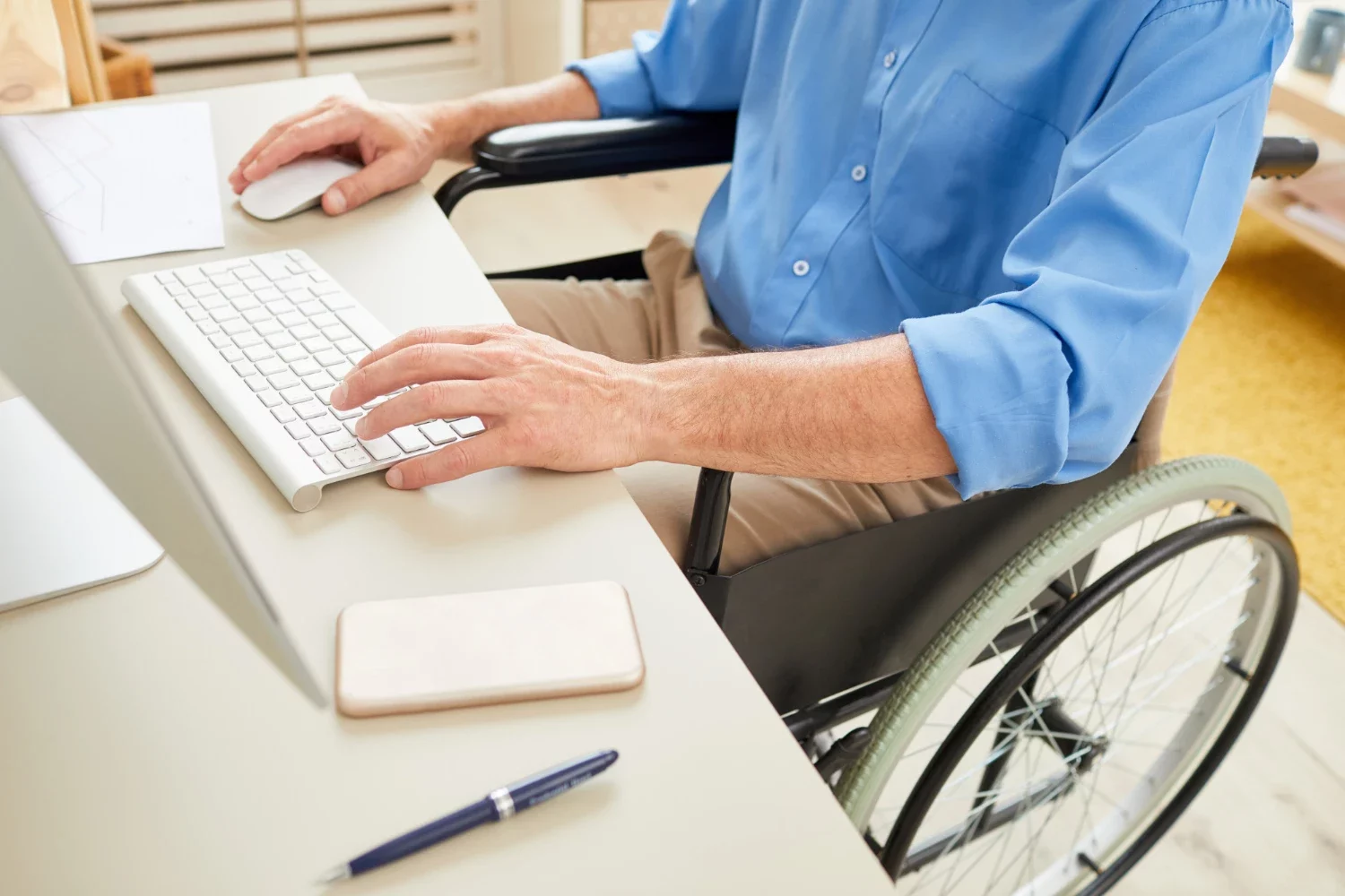 Uomo in sedia a rotelle che scrive una mail